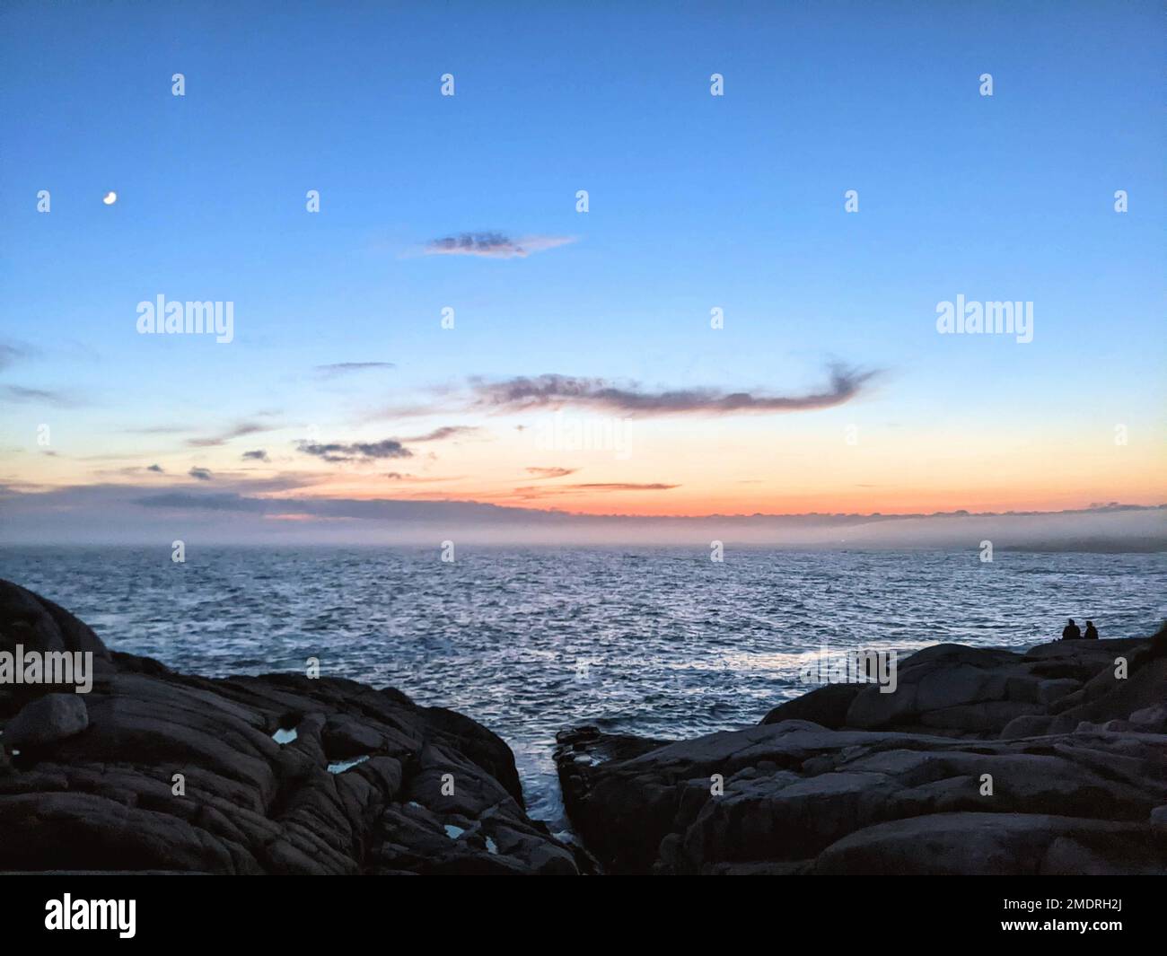 The view of the rocky coastline and sea at sunset Stock Photo - Alamy