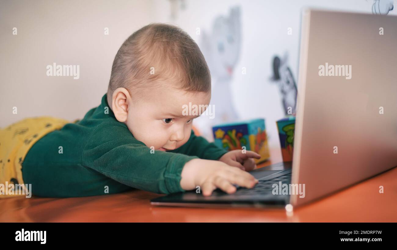 Portrait of baby boy using a laptop computer at his business office ...