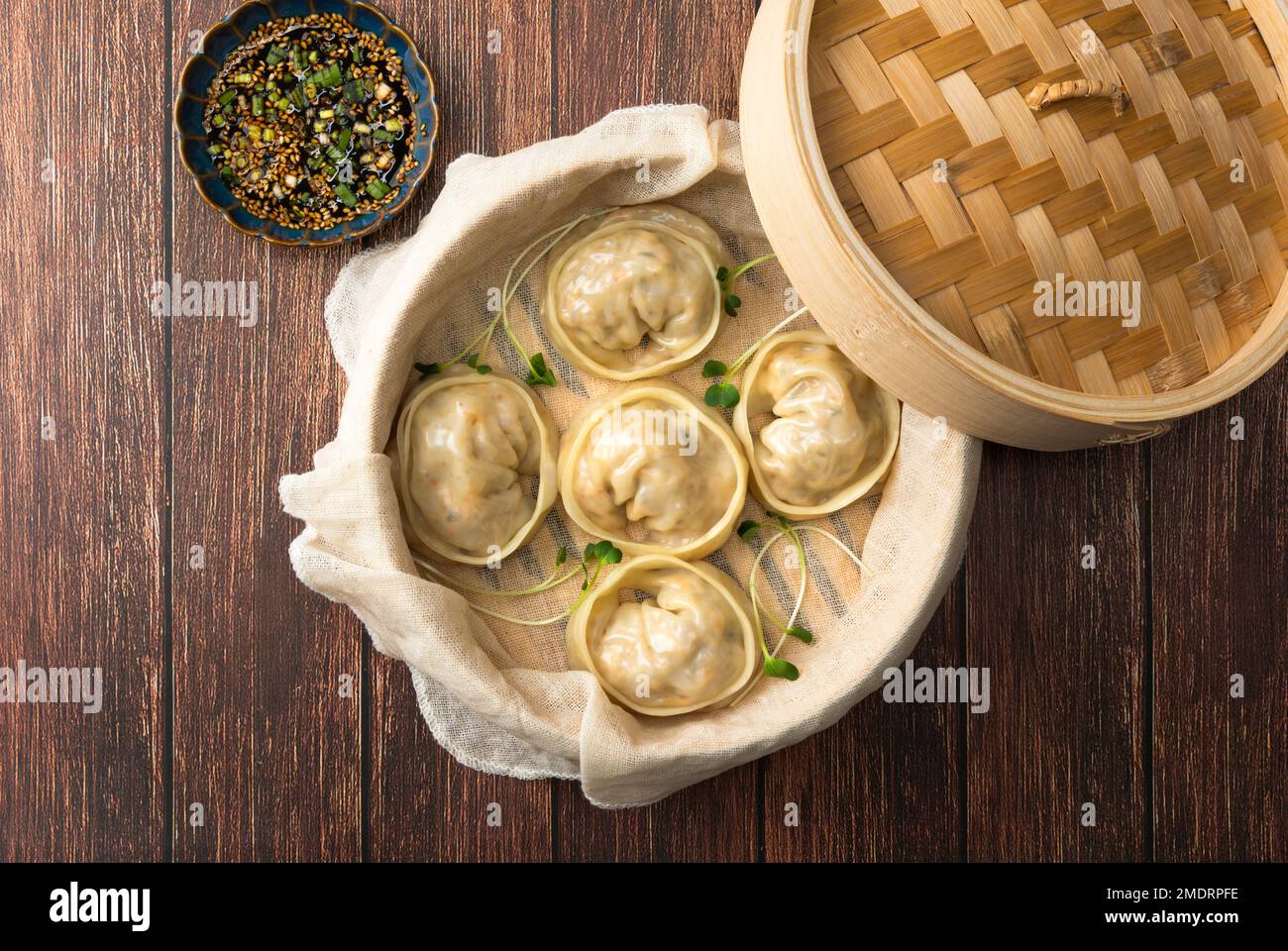 Delicious homemade Korean kimchi dumplings in a bamboo steamer viewed from above. Stock Photo