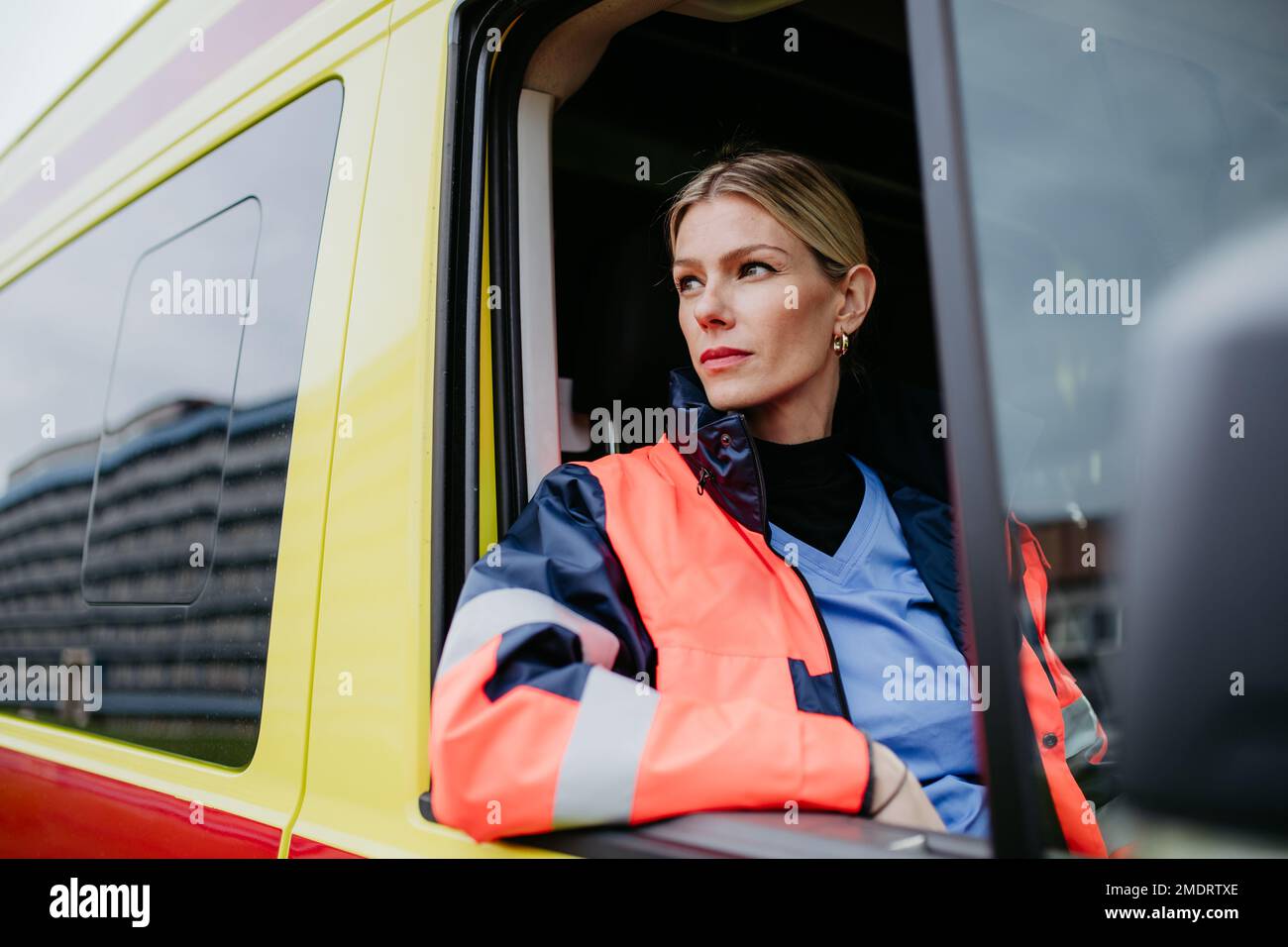 Portrait of young woman doctor sitting in ambulance car. Stock Photo