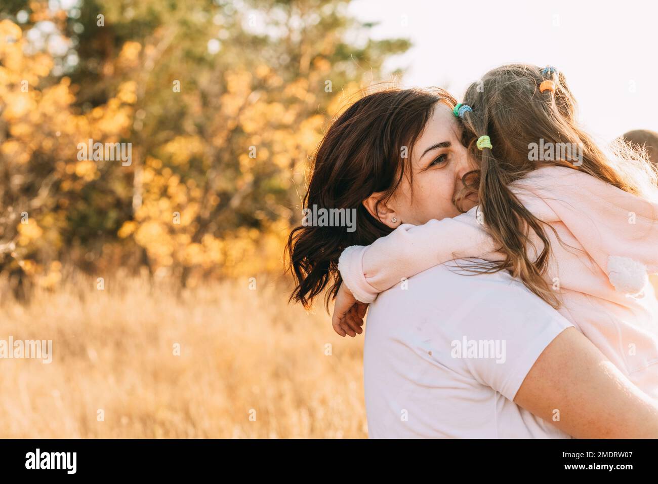 Beautiful Young Woman And Her Charming Little Daughter Are Hugging And ...