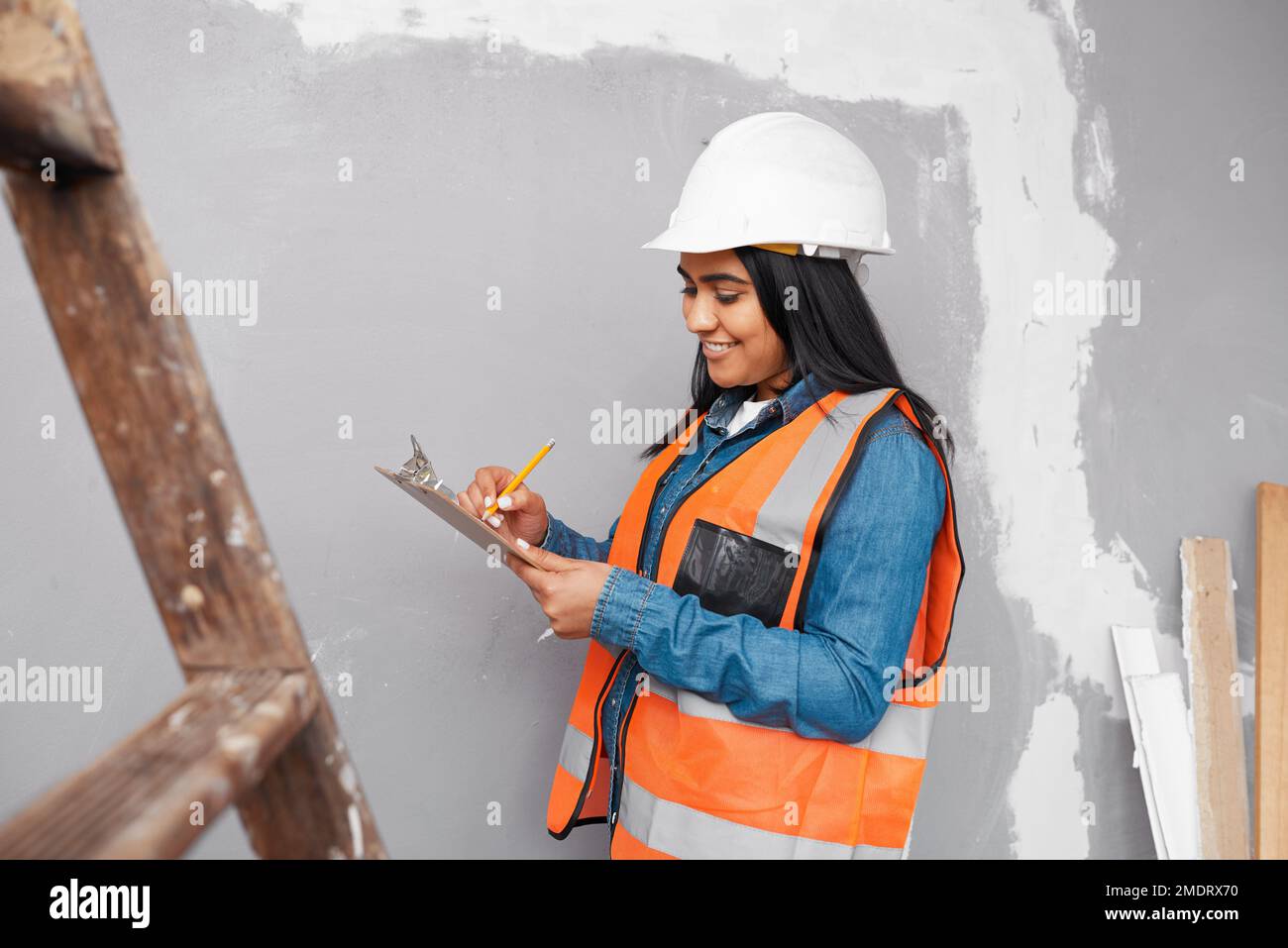 A construction supervisor checks renovation project with checklist on clipboard Stock Photo