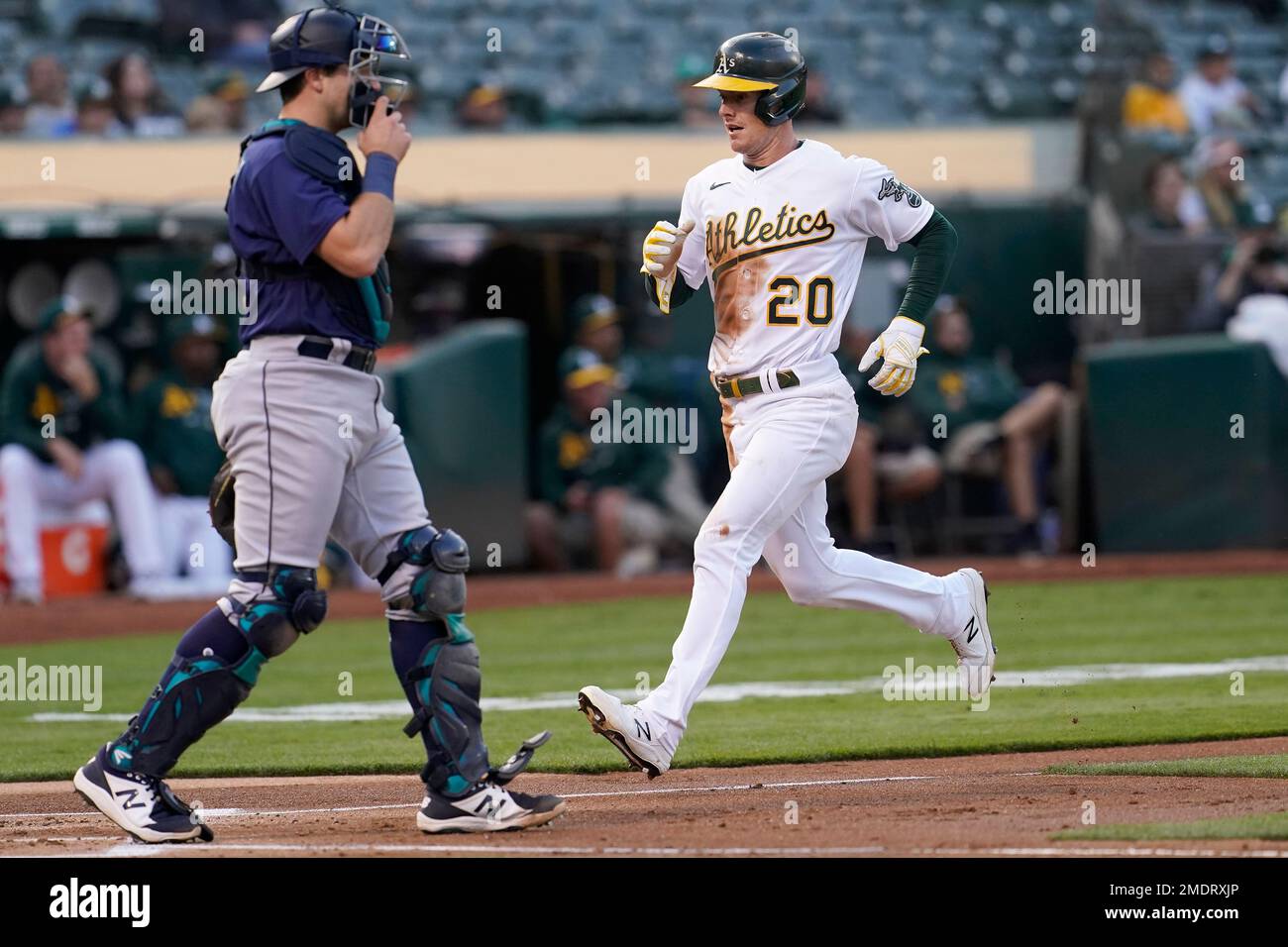 Oakland Athletics' Mark Canha, right, runs home to score behind Seattle ...