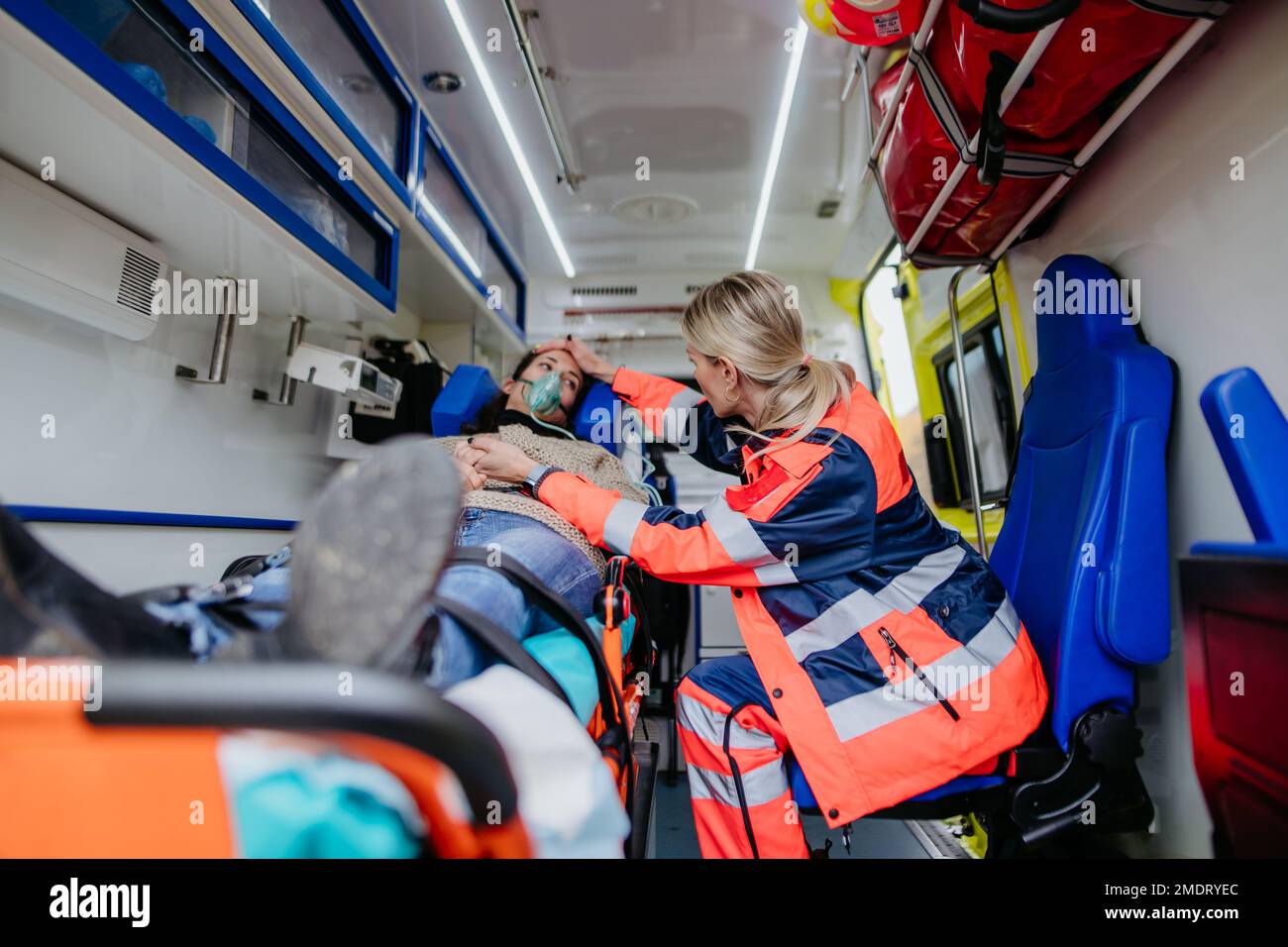 Rescuer taking care of patient, preparing her for transport. Stock Photo