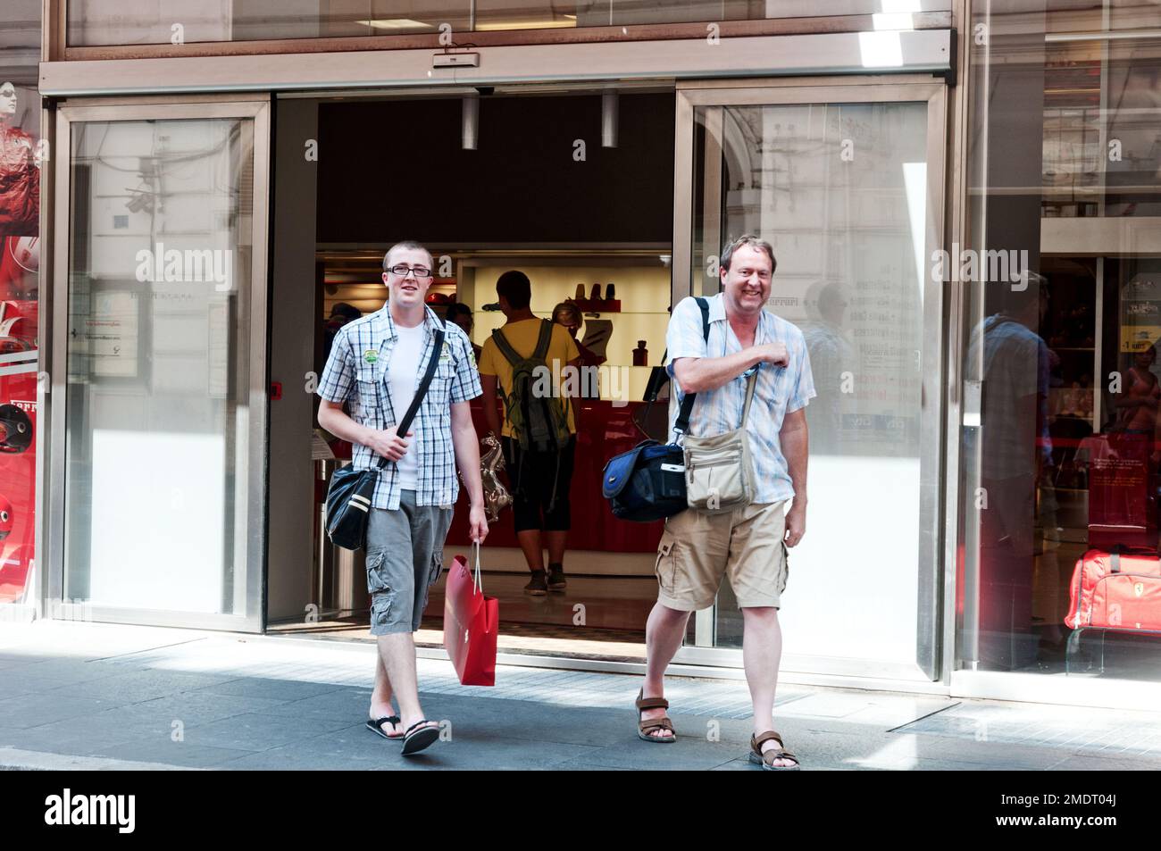 Father and son leaving Ferrari store smiling in Rome, Italy Stock Photo