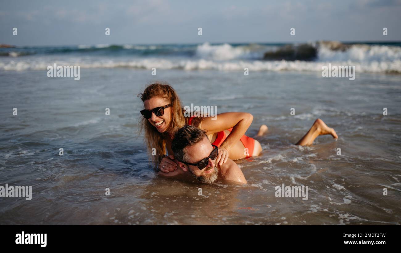 Happy couple in water, enjoying sea together. Stock Photo
