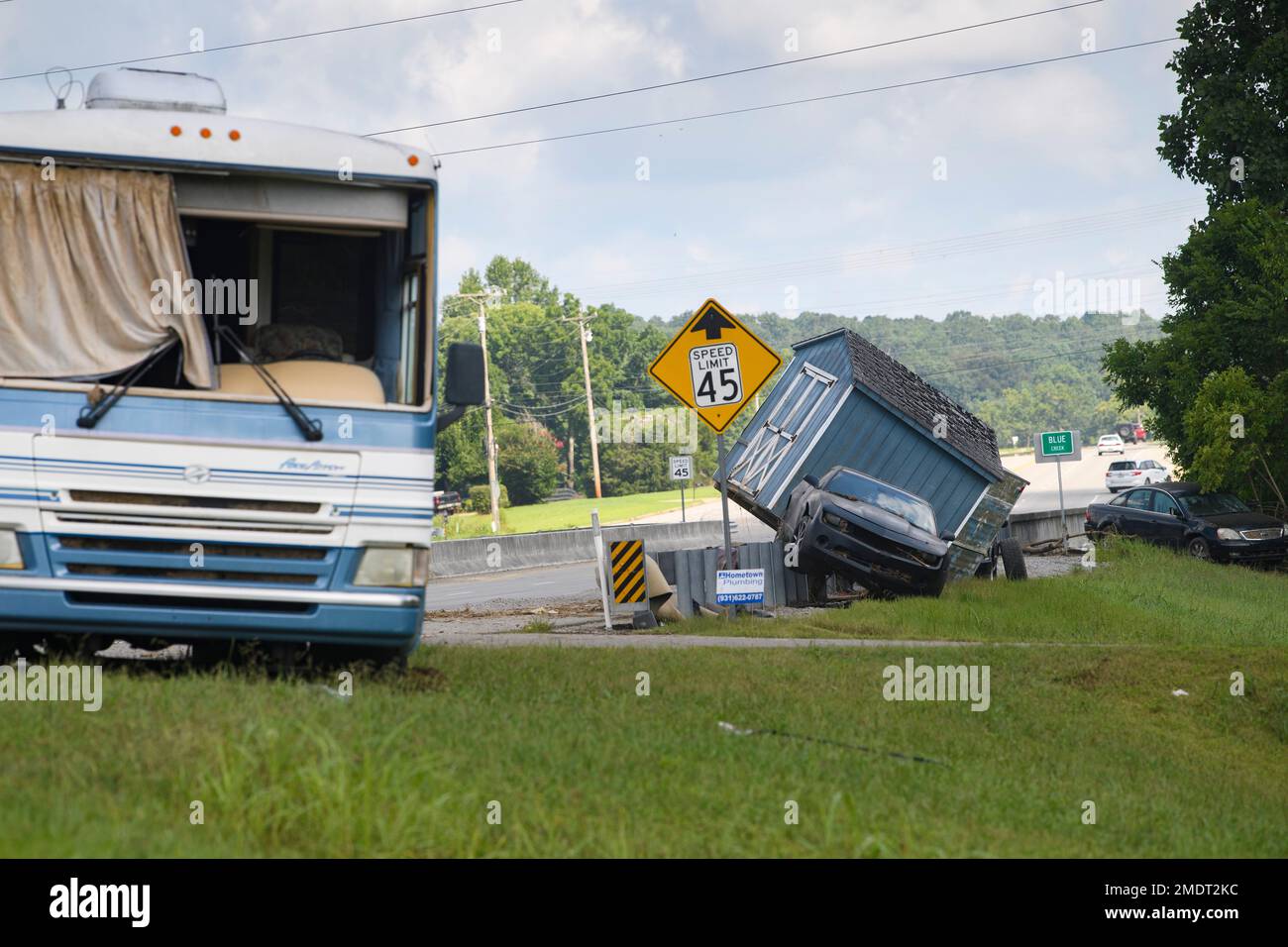 A shed, car, and RV came to a rest on Hwy 13, after being swept up in