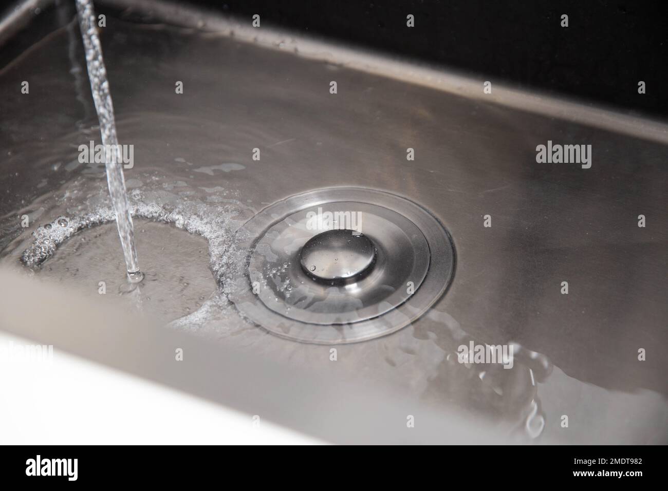 Modern stainless steel sink with plug for draining water and filling