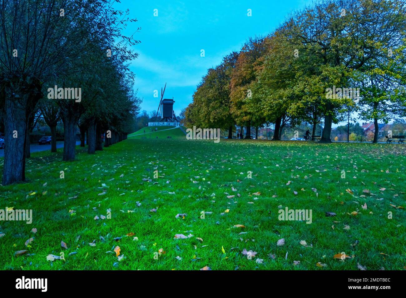 The 18th century Sint-Janshuismolen windmill along the canal that encircles the medieval city of Bruges Belgium. November 2022 Stock Photo