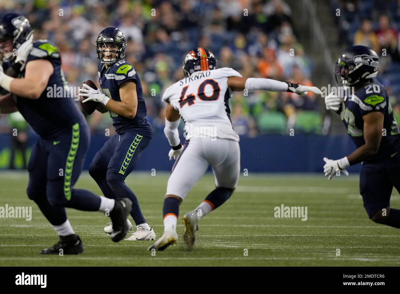 Seattle Seahawks quarterback Alex McGough drops to pass as Denver Broncos  linebacker Justin Strnad rushes during the first half of an NFL preseason  football game, Saturday, Aug. 21, 2021, in Seattle. DeShawn