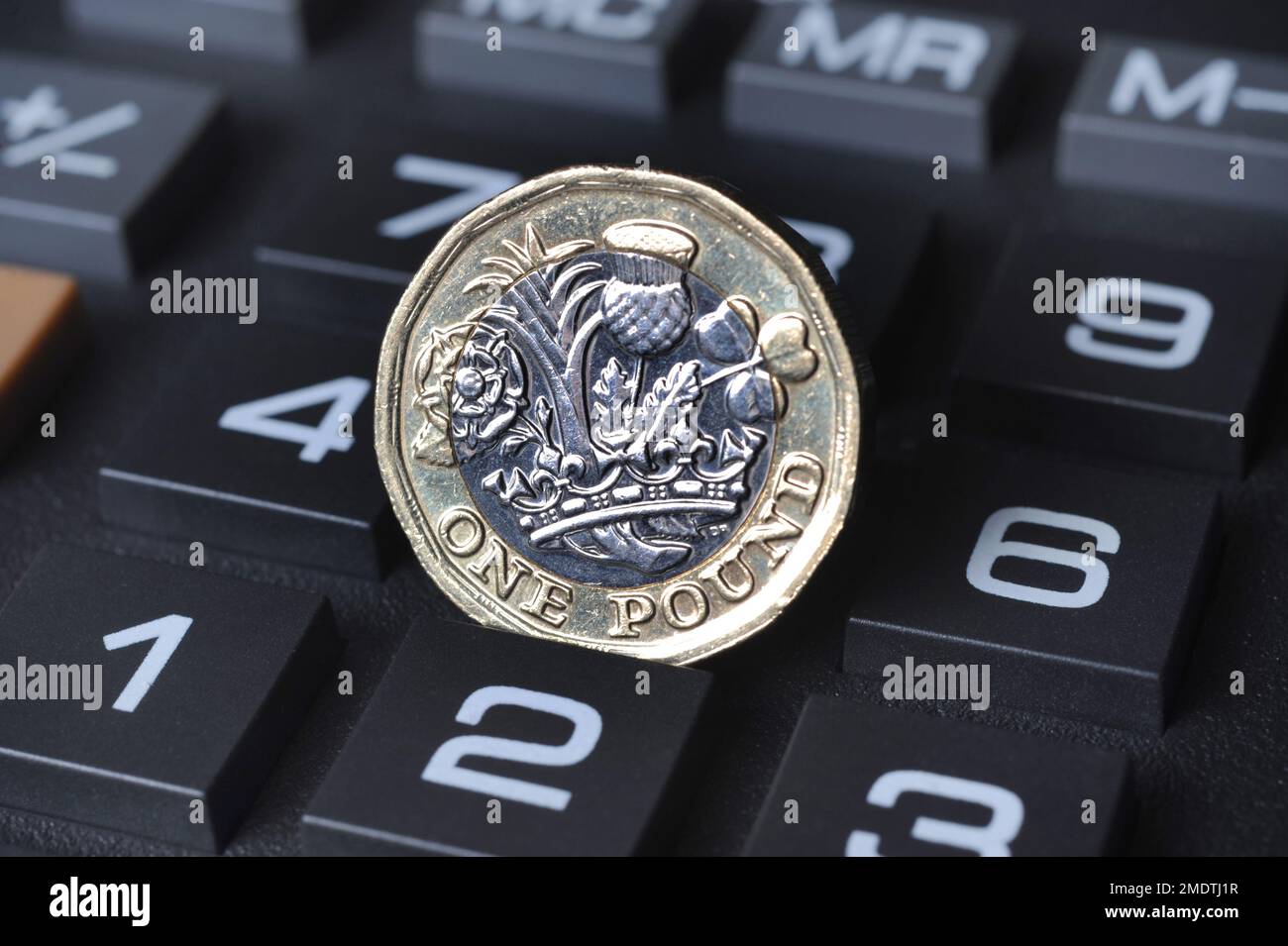 ONE POUND COIN ON CALCULATOR RE COST OF LIVING CRISIS MORTGAGES INFLATION INTEREST RATES THE ECONOMY ETC UK Stock Photo