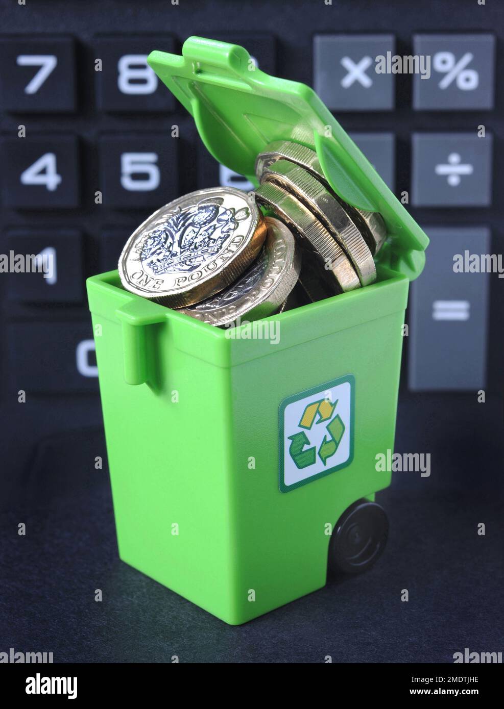 RECYCLING WHEELIE BIN WITH ONE POUND COINS RE THE ENVIRONMENT RECYCLE COSTS PRICES RUBBISH CLIMATE CHANGE CRISIS ETC UK Stock Photo