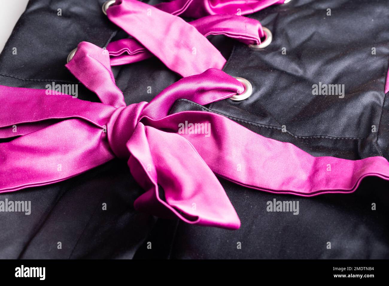 Pink Cord In Fashionable Black Lace Up Dress, macro. Background, textured Stock Photo