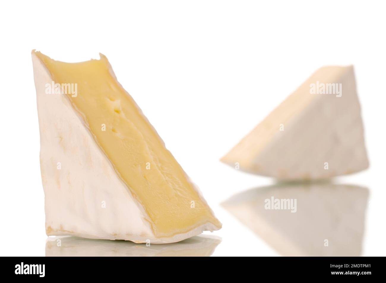 Two pieces of fragrant brie cheese, macro, isolated on white background