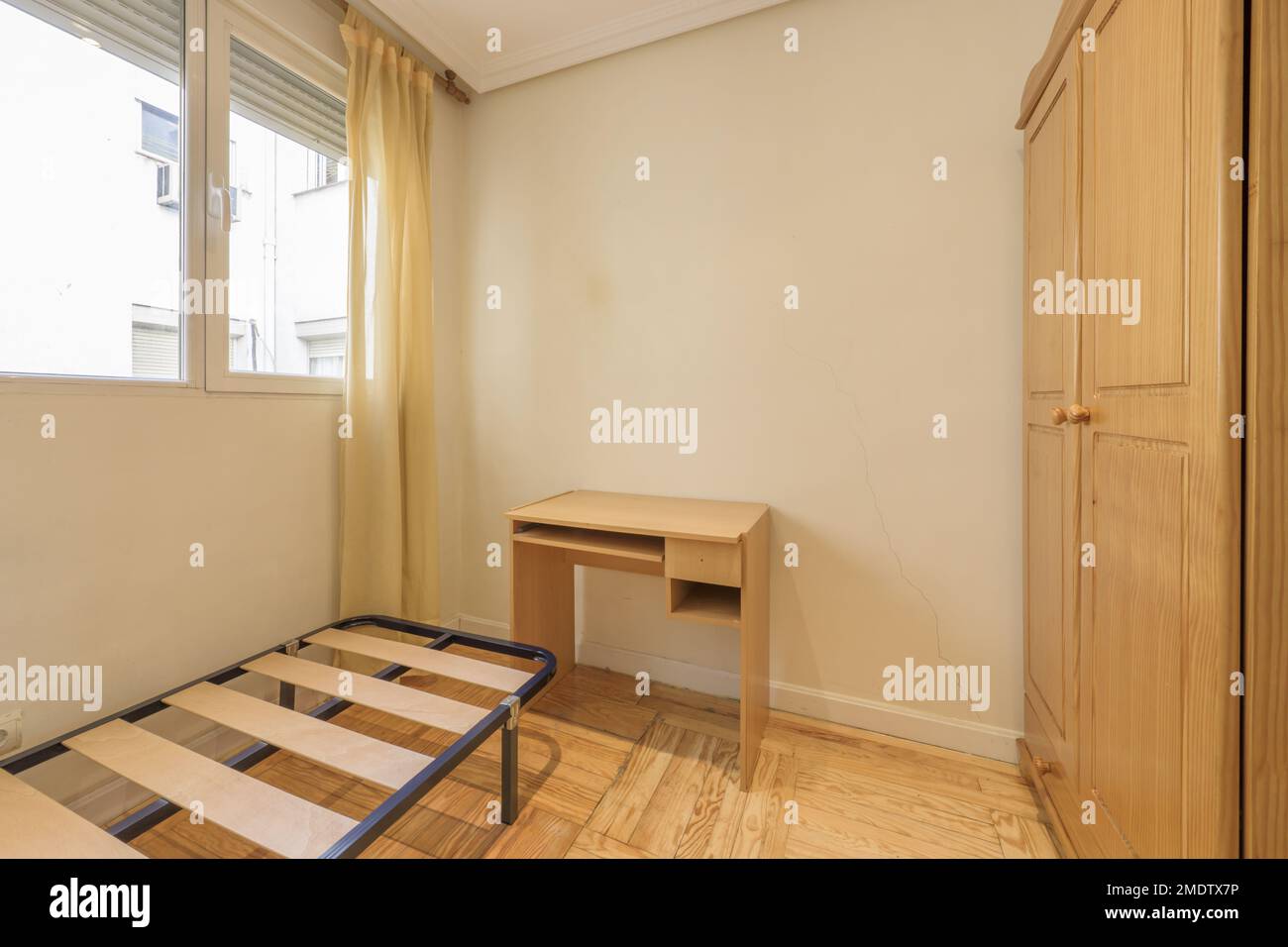 Bedroom with oak wardrobe, cheap desk, box spring without mattress and