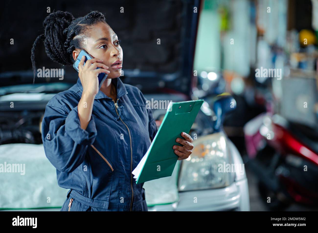 Car service Garage staff worker contact customer call talking replace auto part list and price Stock Photo