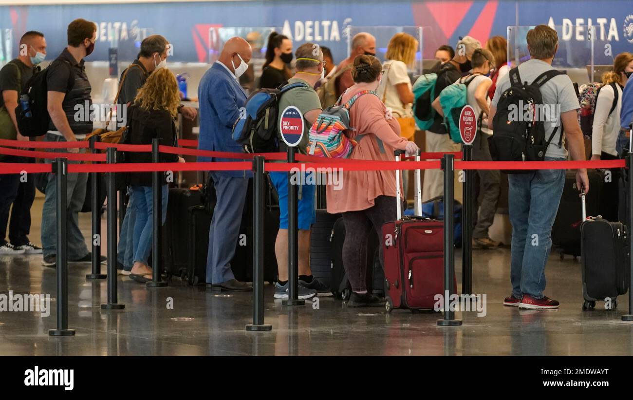 Travelers wait to check in at the delta ticket counter at Salt Lake