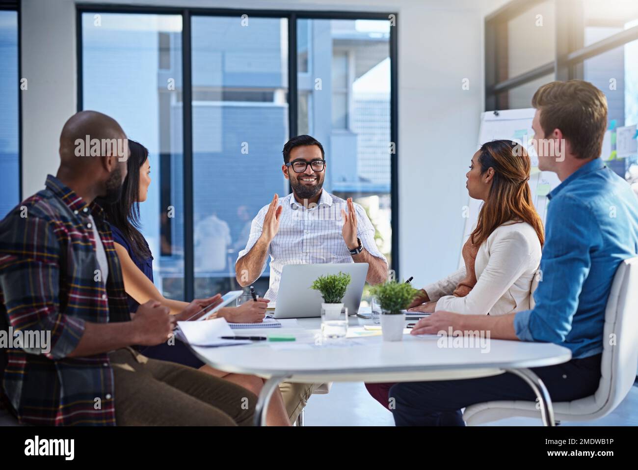 This is how much we need grow weekly. a group of young businesspeople discussing ideas with each other during a meeting in a modern office. Stock Photo