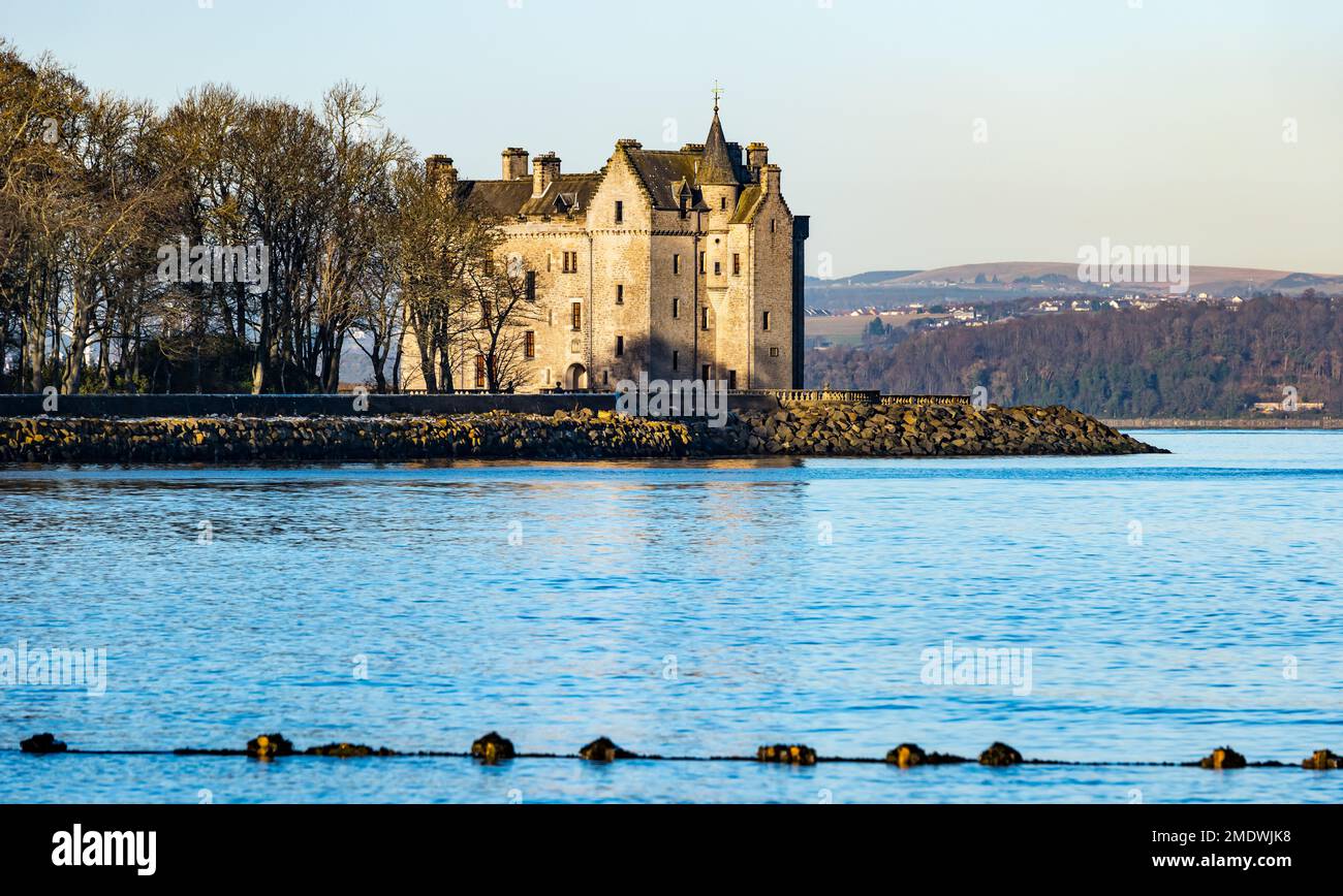 Barnbougle Castle on Dalmeny Estate on the shoreline of the Firth of Forth on a sunny day with snow covered Ochill Hills, Scotland, UK Stock Photo