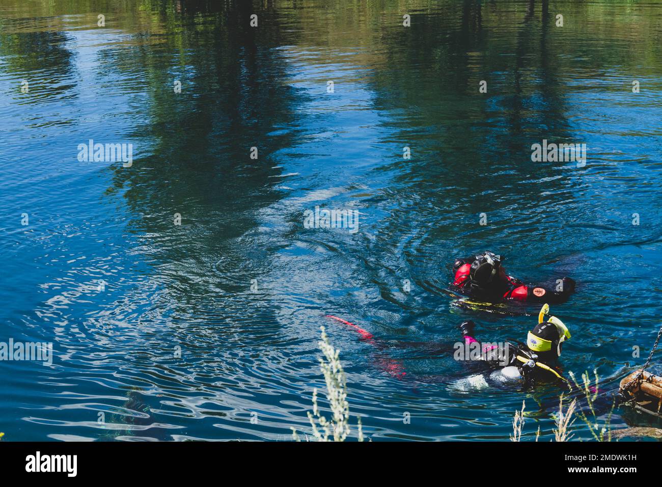 Divers in water. Study of river bottom. Search for missing people. Lifting drowned cargo to surface. People in water. Stock Photo