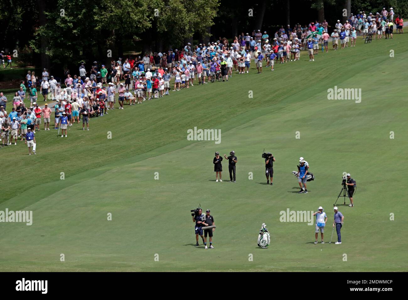 Fans watch as the final group approaches the 18th hole during the final round of the Wyndham Championship golf tournament at Sedgefield Country Club in Greensboro, N.C., Sunday, Aug
