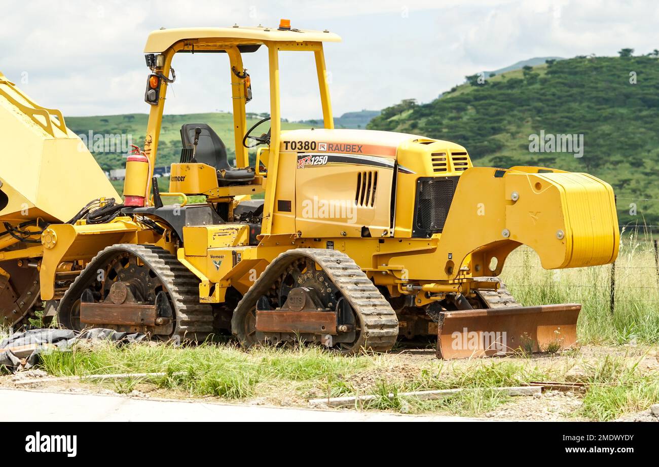 yellow utility tractor or ride on tractor with quad track system concept heavy duty machinery used in agricultural, industrial sector in South Africa Stock Photo