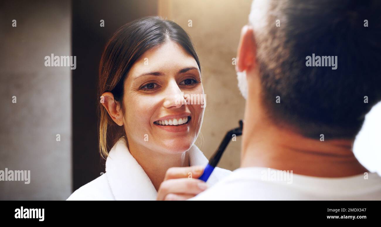 Shes his own personal groomer. a woman shaving her husbands facial hair