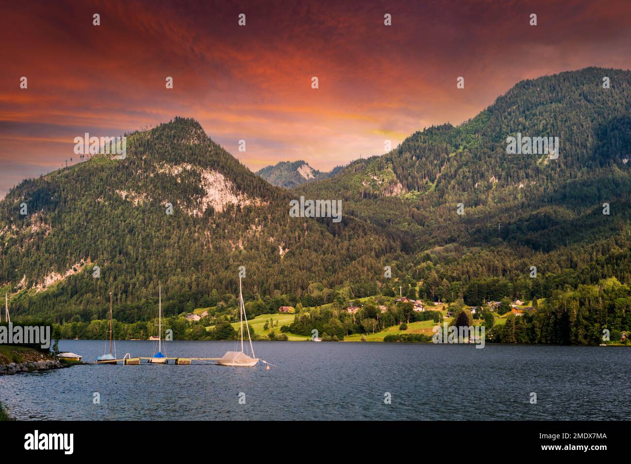 A sunset by lake in Austria. The lake is surrounded by high Alps. Stock Photo