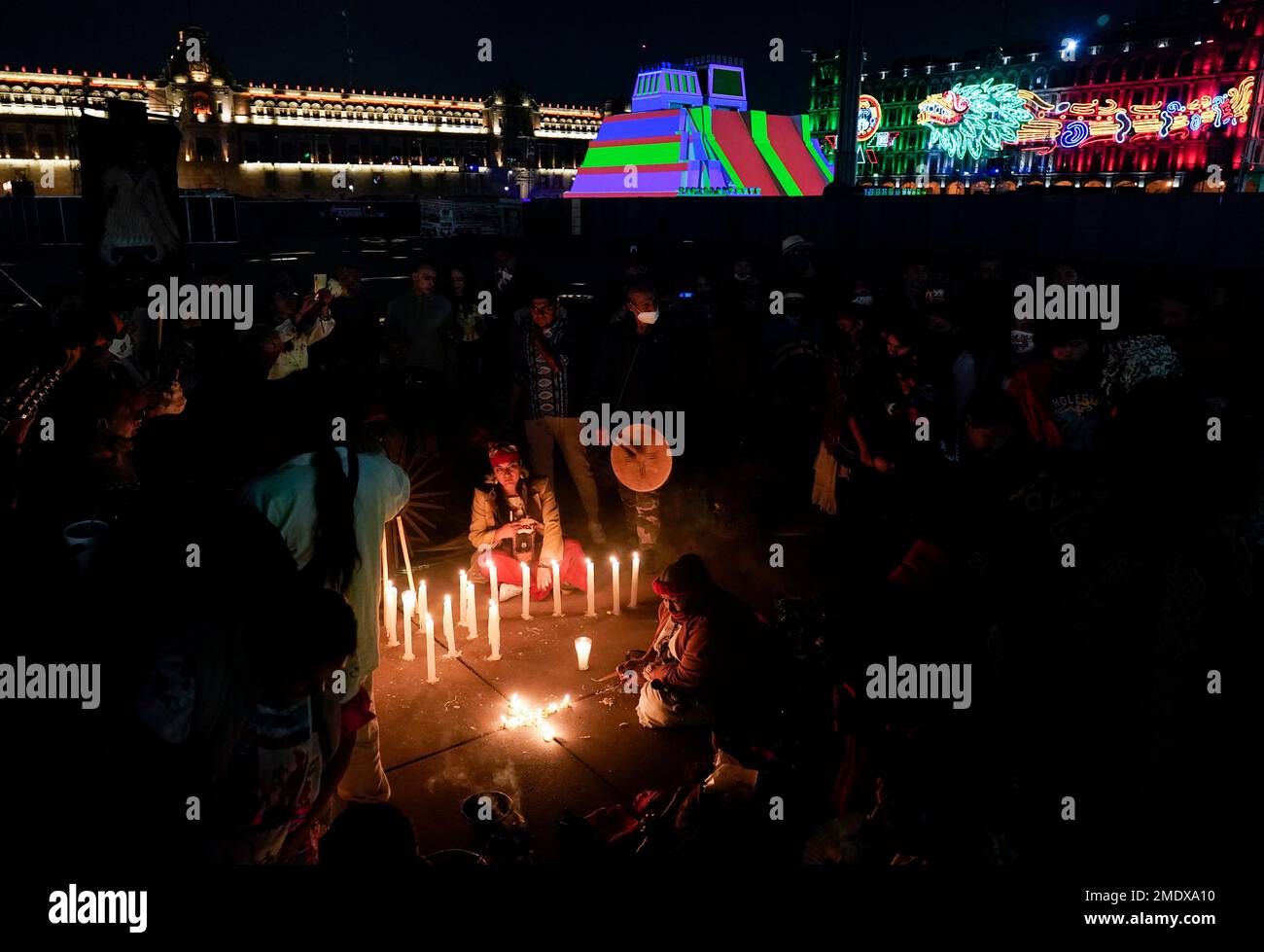 Mexican dancers light a candle during a ceremony to commemorate the ...