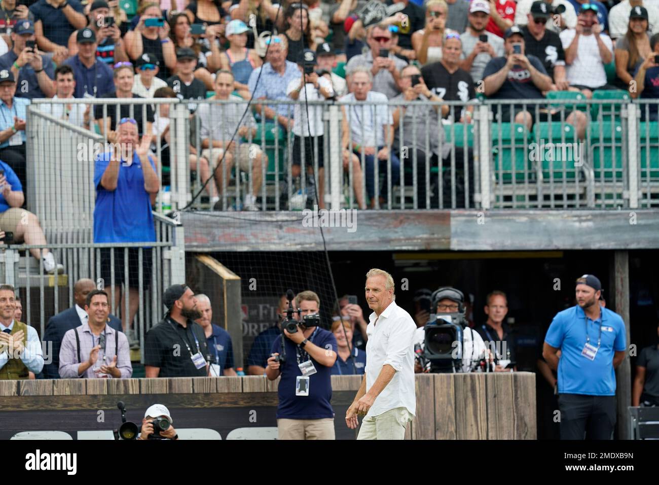 Actor Kevin Costner walks to the stands before a baseball game between