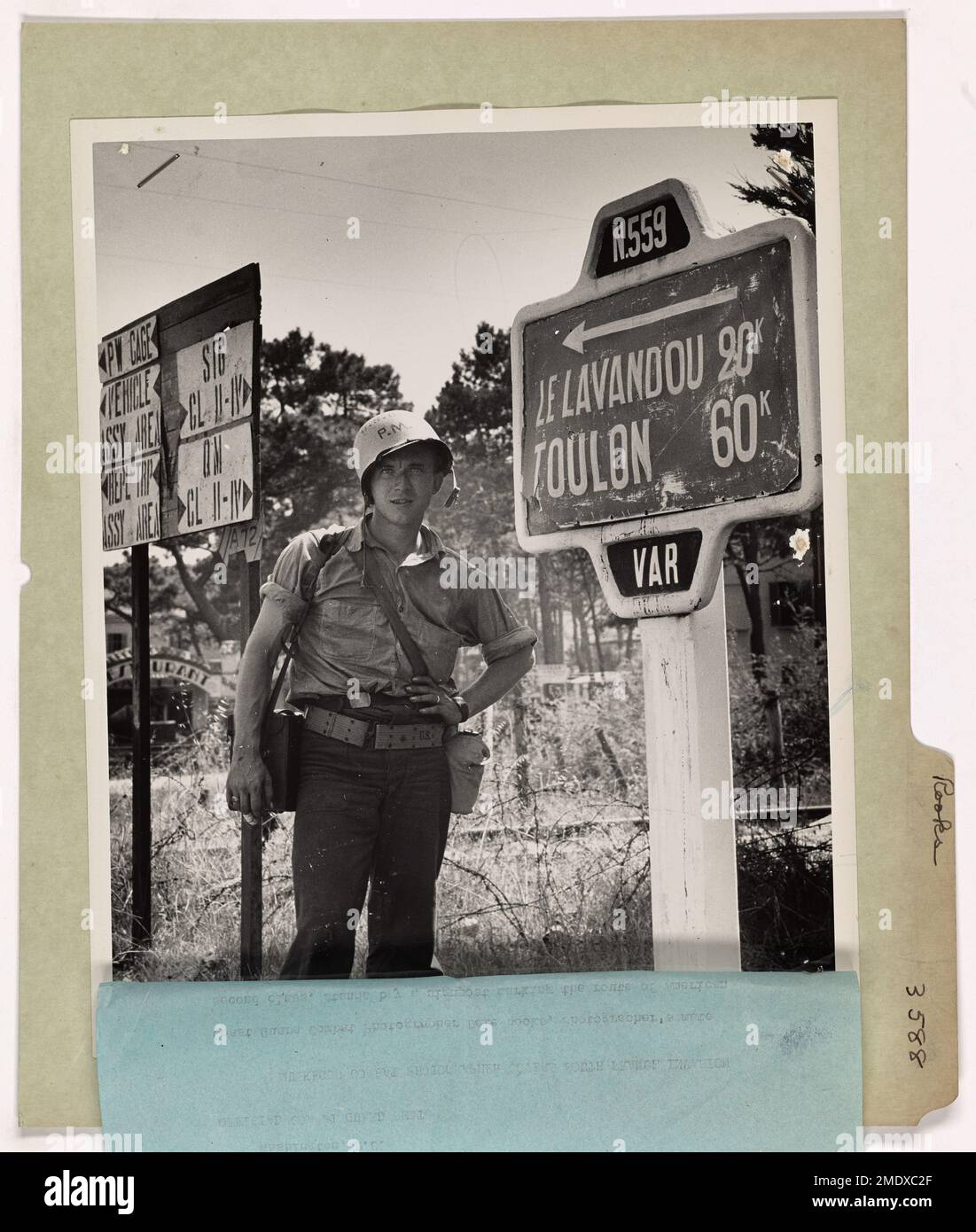 Coast Guard Combat Photographer Dale Rooks stands by a signpost marking ...
