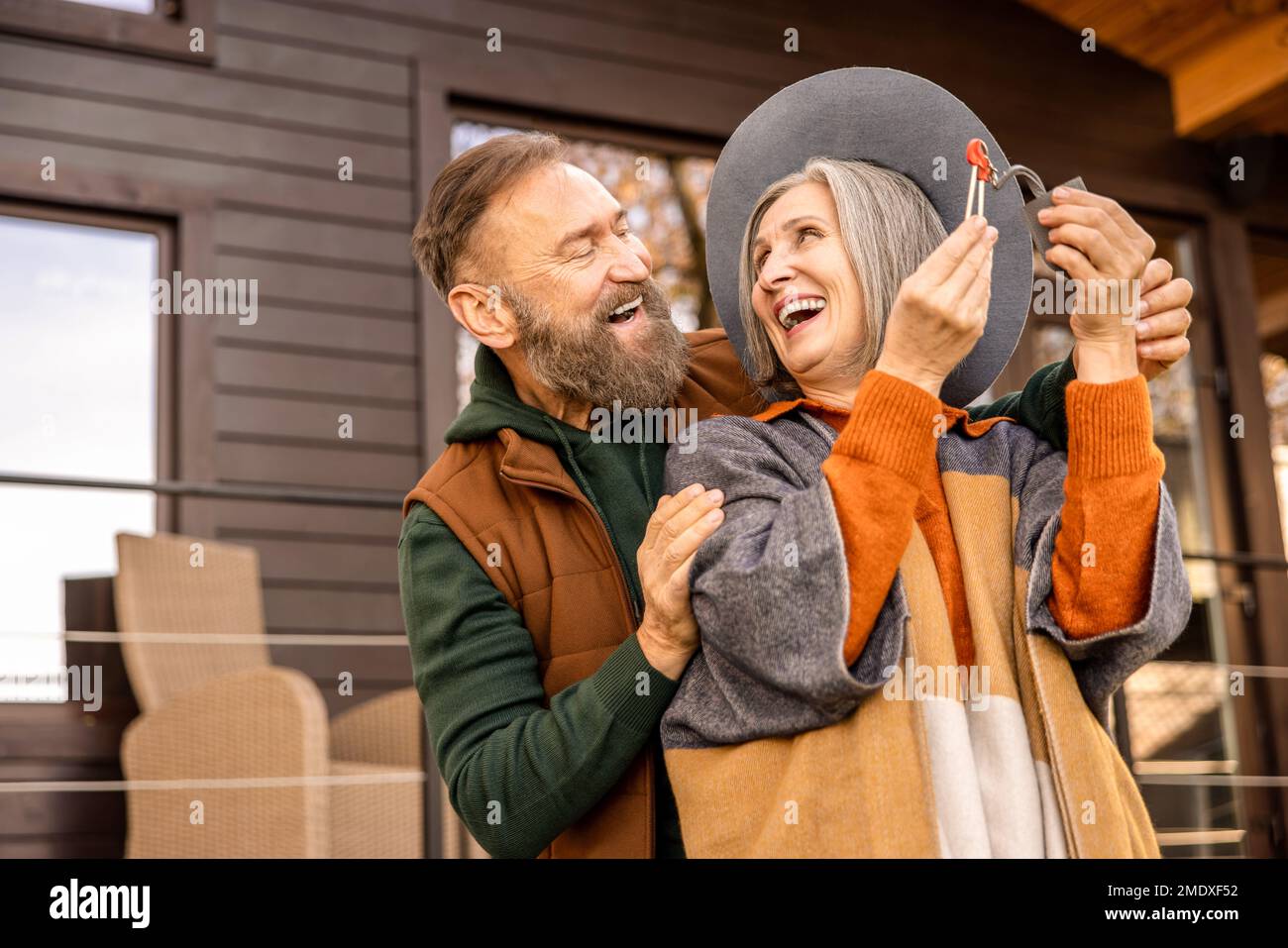 Happy man making a surprise to his beloved woman and giving her key from new home Stock Photo