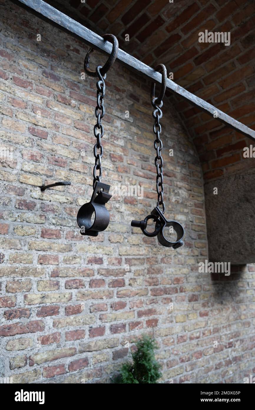 Historic prisoner chain on metal bar against a wall in 16th century