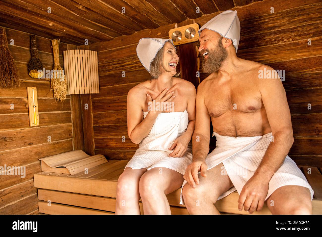 Naked woman sitting in sauna and man looking through window Stock Photo -  Alamy