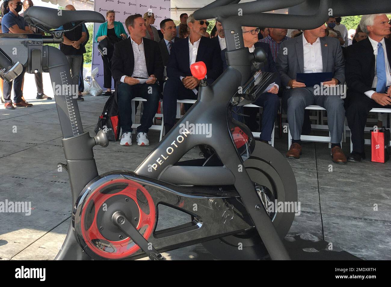 Peloton CEO John Foley, left, is seen behind one of his company's