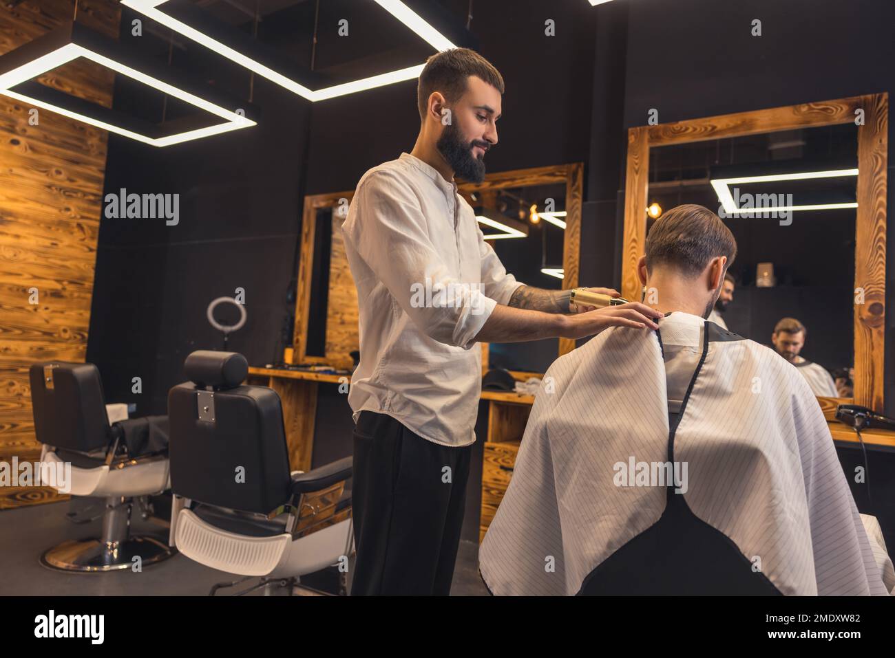 Barber shaving the clients neck with electrical razor Stock Photo