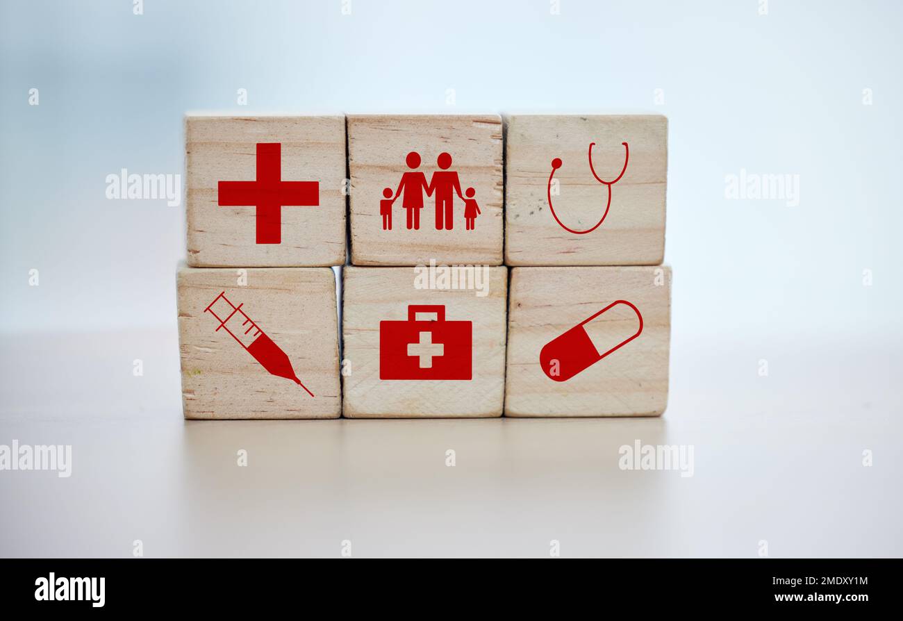 Health, insurance and wooden blocks on empty table in grey studio background for safety or security. healthcare logos, medicine and abstract block Stock Photo