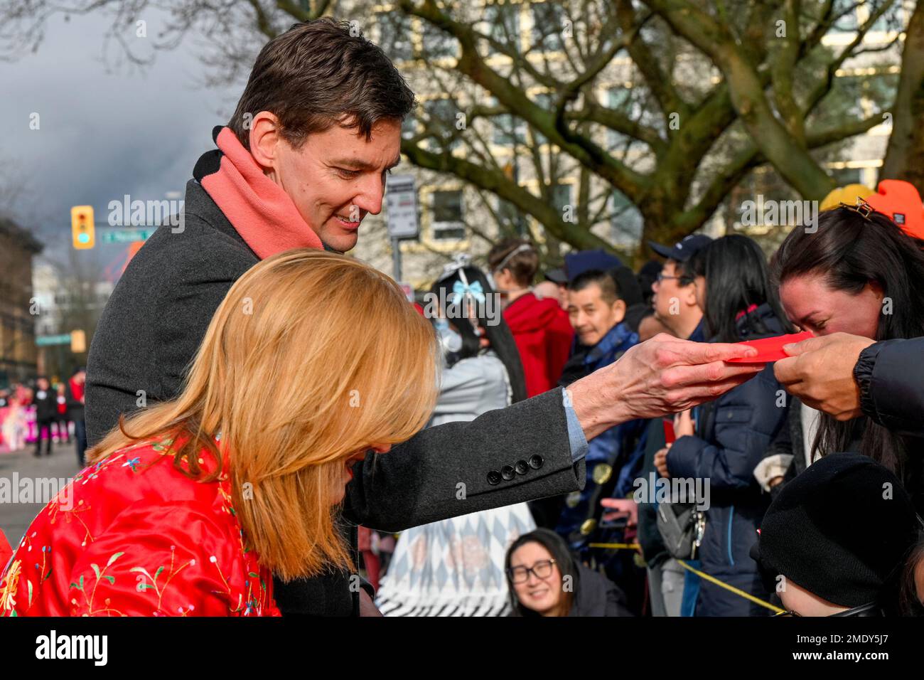 BC Premier David Eby, hands out red Lucky money Envelope, Chinese Lunar New Year Parade, Chinatown, Vancouver, British Columbia, Canada. Stock Photo