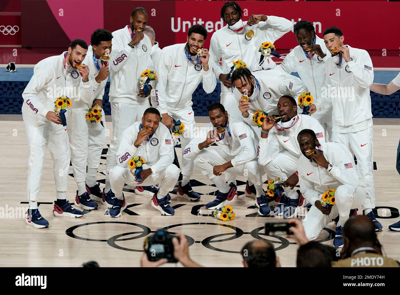 The U.S. men's basketball team poses for photos with their gold medals during the medal ceremony