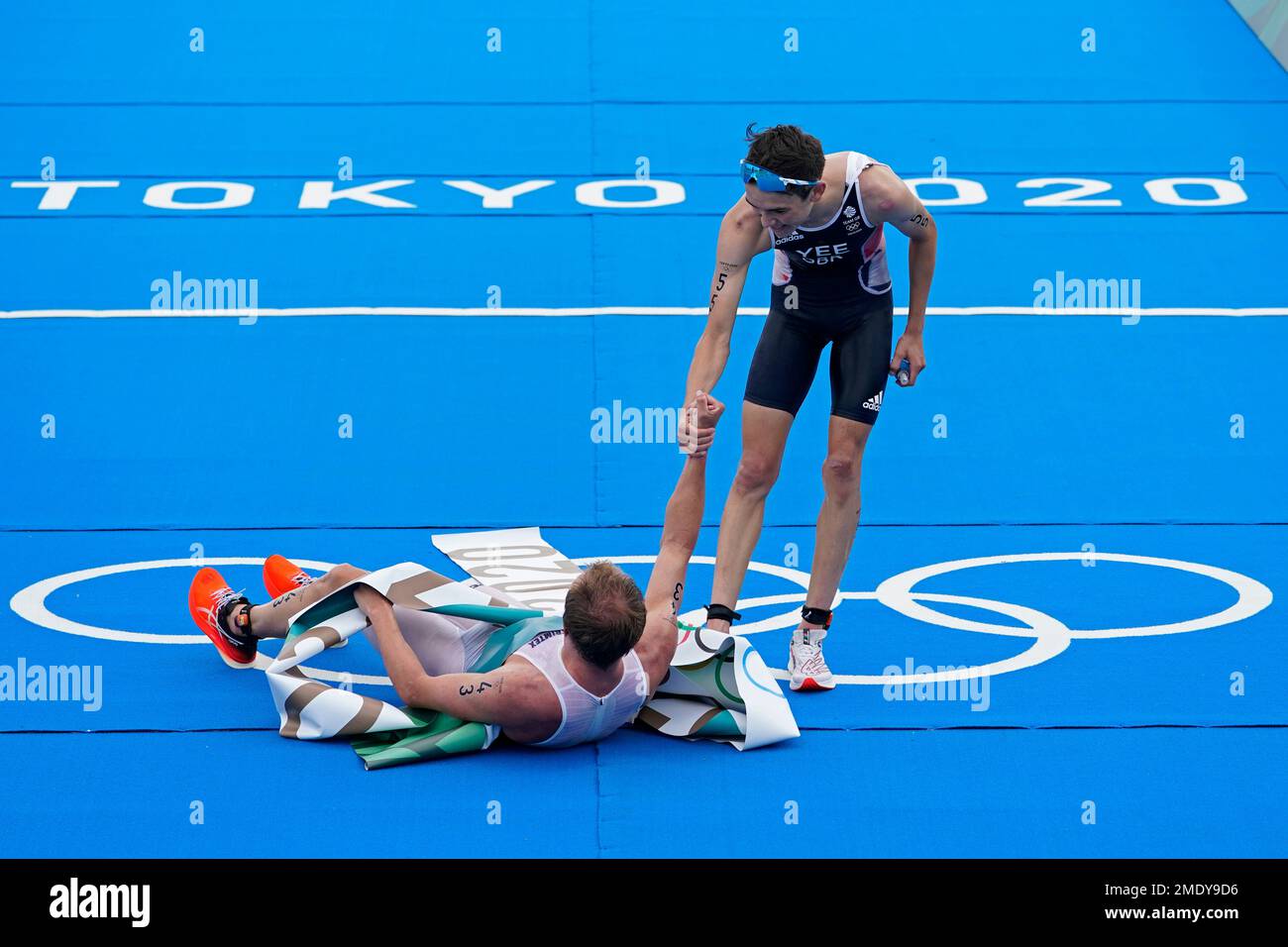 Alex Yee of Great Britain (55) reaches to help up Kristian Blummenfelt