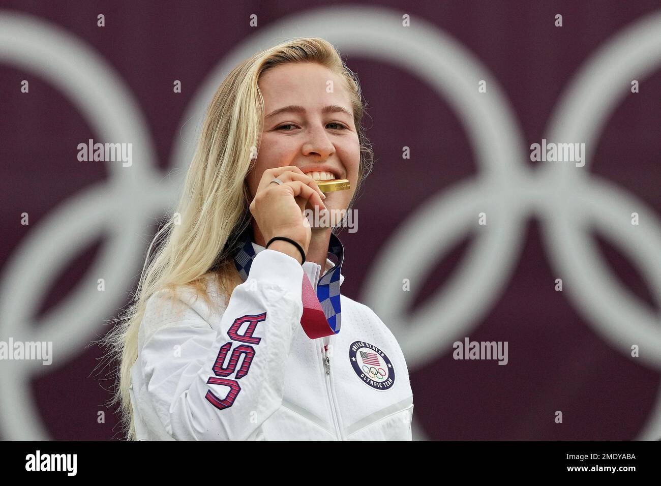 Nelly Korda, of the United States, bites her gold medal of the women's