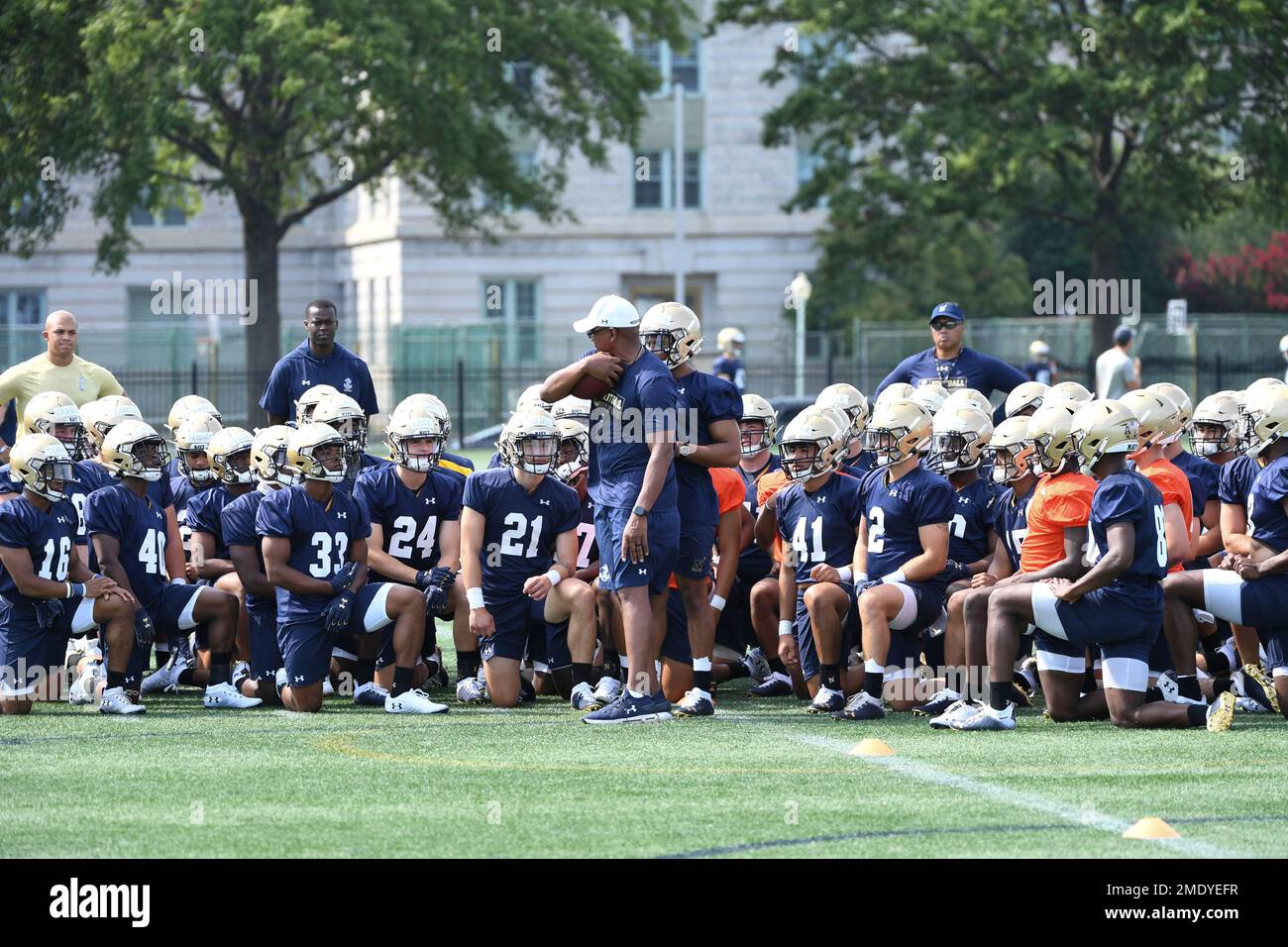 Navy players listen in on ball protection instructions during work outs