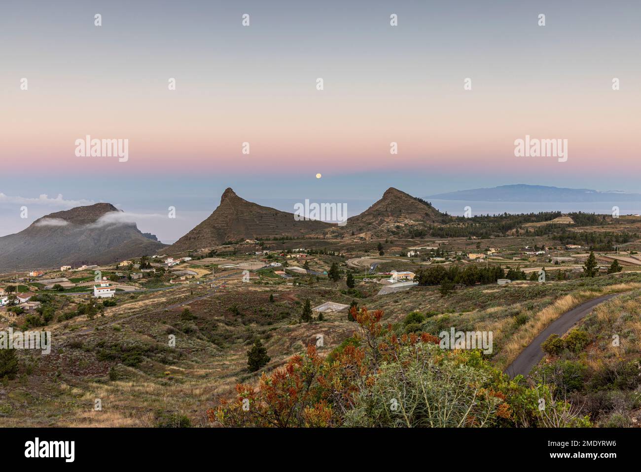 View over the village of Ifonche to the coastal resorts of Los Cristianos and Las Americas at dawn with the full moon setting in the west, Adeje, Tene Stock Photo