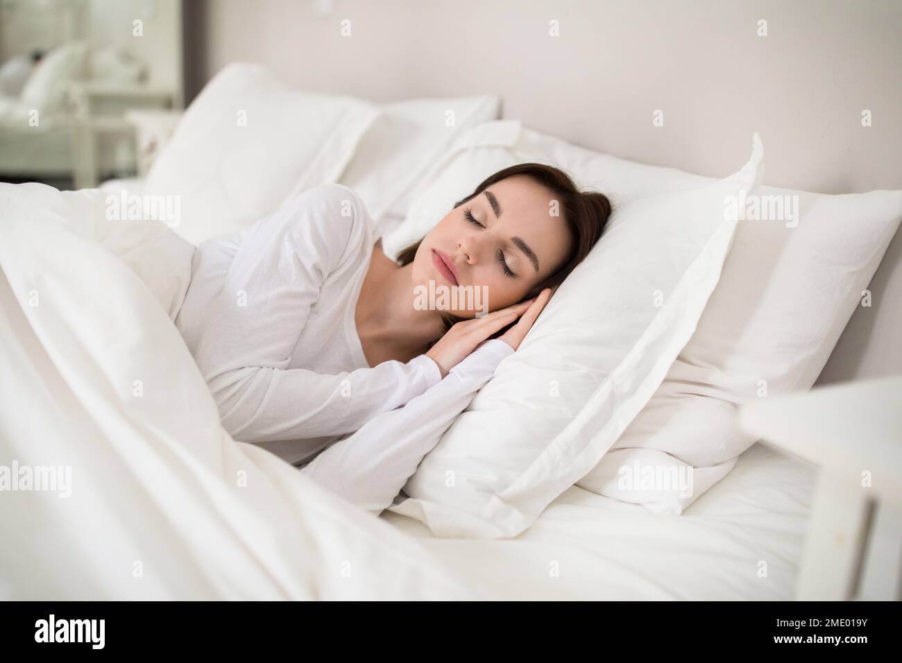Beautiful young woman sleeping with hands under her head Stock Photo