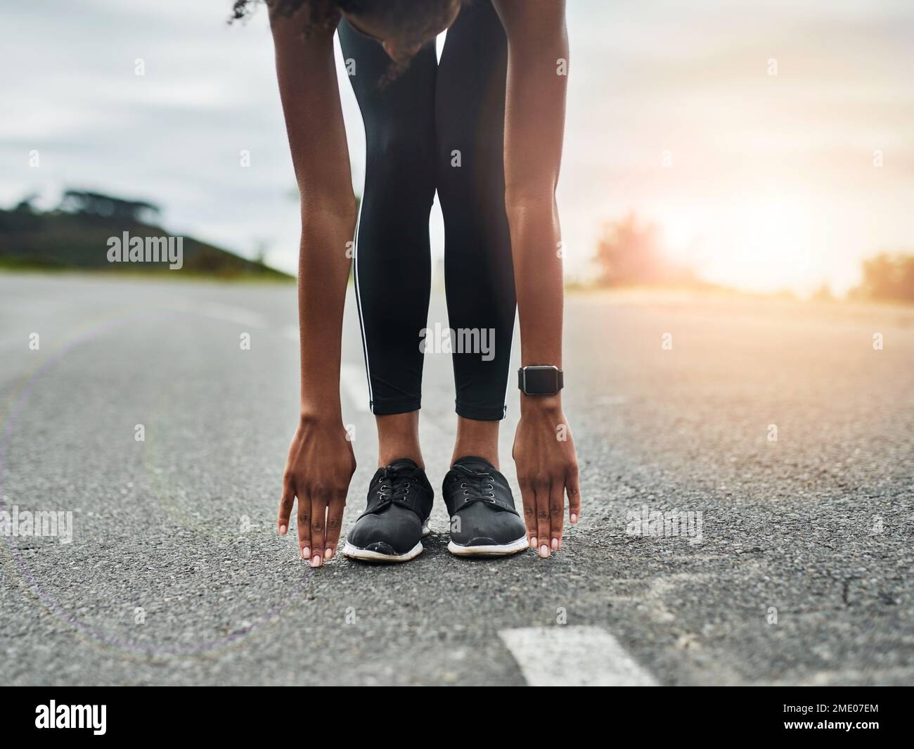 Stretch it out. an unrecognizable young sportswoman warming up for a workout outdoors. Stock Photo