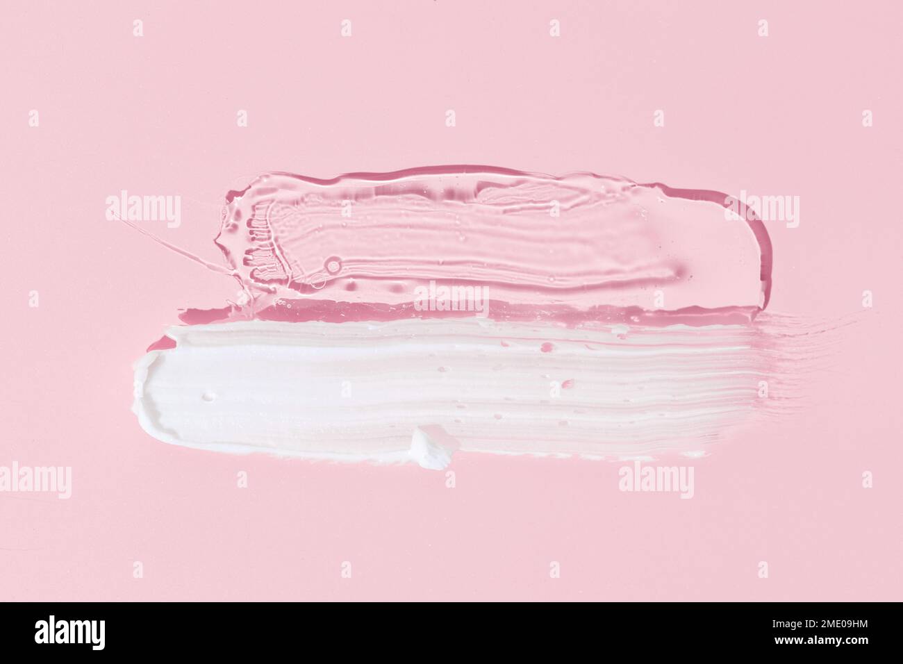 White cream and clear gel cosmetic smudge drops texture isolated on pink background. Cosmetic smears Stock Photo
