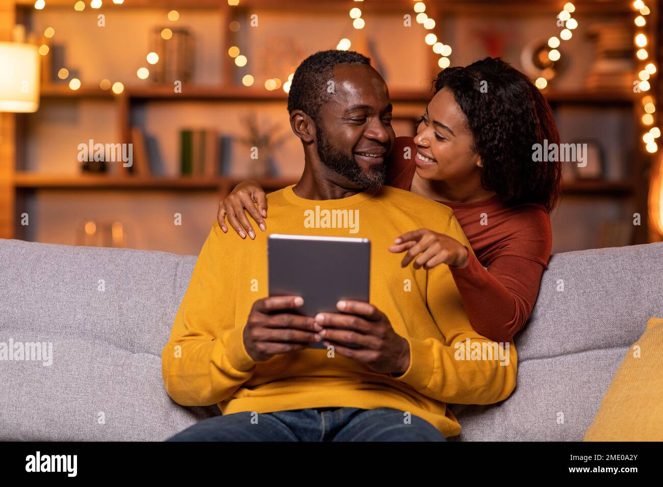 Married black couple using digital tablet at cozy winter evening Stock Photo
