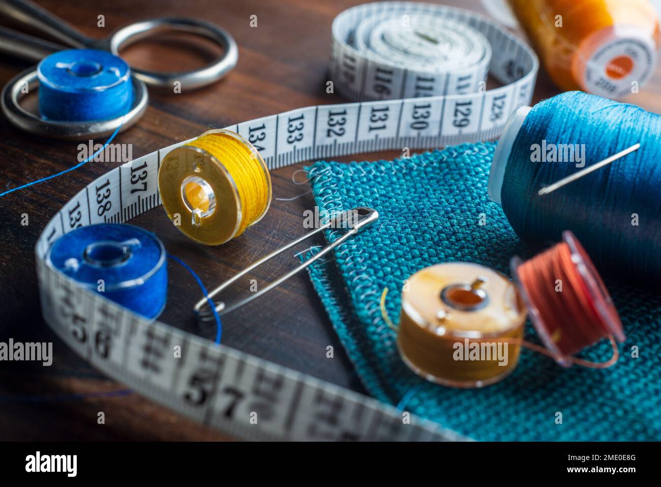 Premium Photo  Red, orange and green thread spool. scissors and seamstress  tape measure on a wooden background.