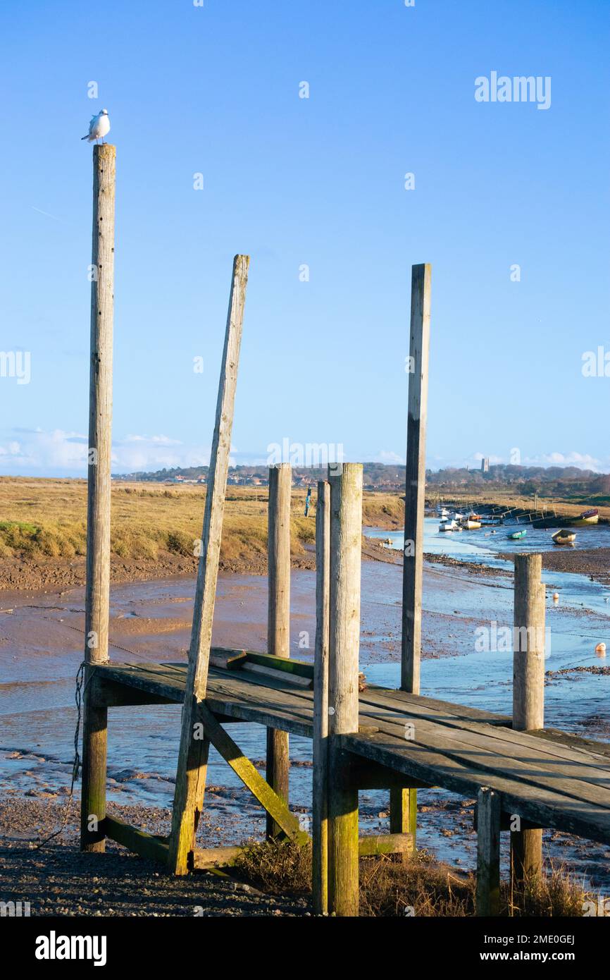 View accross the Morston creek with boats aground at low tide looking towards Blakeney, North Norfolk East Anglia England Stock Photo