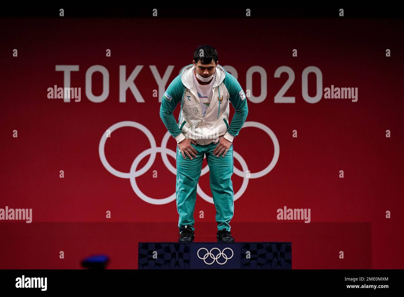 Akbar Djuraev of Uzbekistan bows as he arrives on the medals podium to receive his gold medal in
